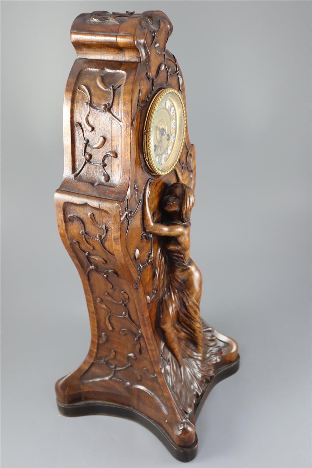 An unusual French Art Nouveau walnut mantel clock, width 9in. height 22.75in.
